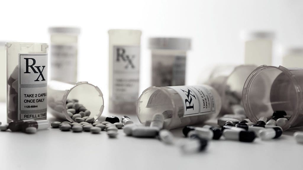 Pills falling out of prescription bottles representing the CSA compliance challenges pharmacies face and how C2 Keep can help clean up the mess.
