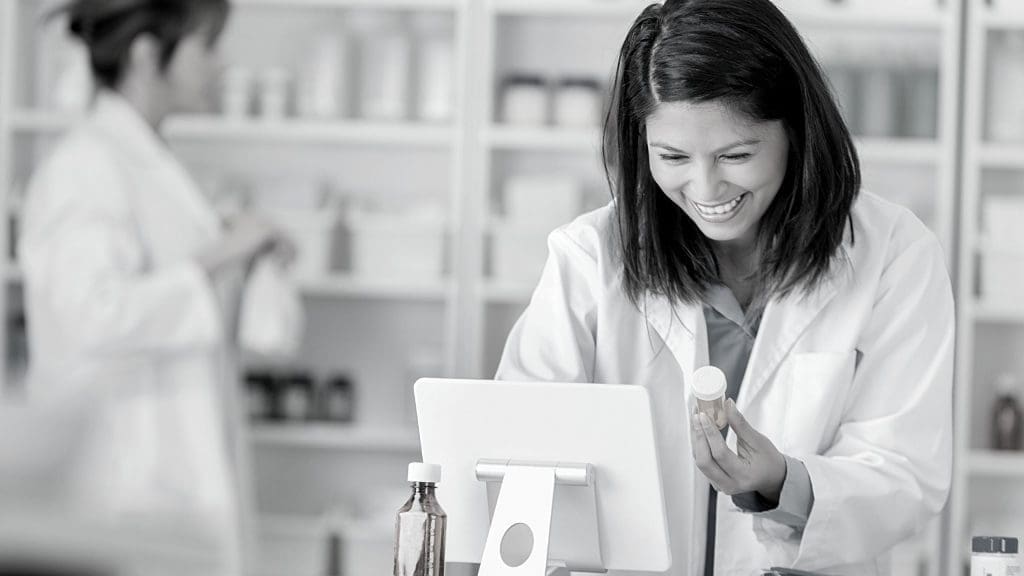 A pharmacist typing records into a tablet, representing how C2 Keep can help ensure a pharmacy is well-prepared for a regulatory drug audit or investigation.