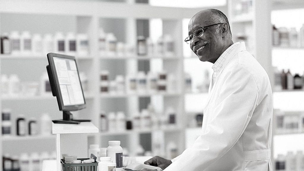 a male pharmacists working on his computer