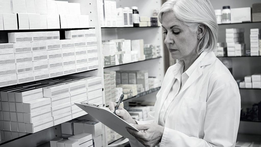 A pharmacist keeping records on a piece of paper
