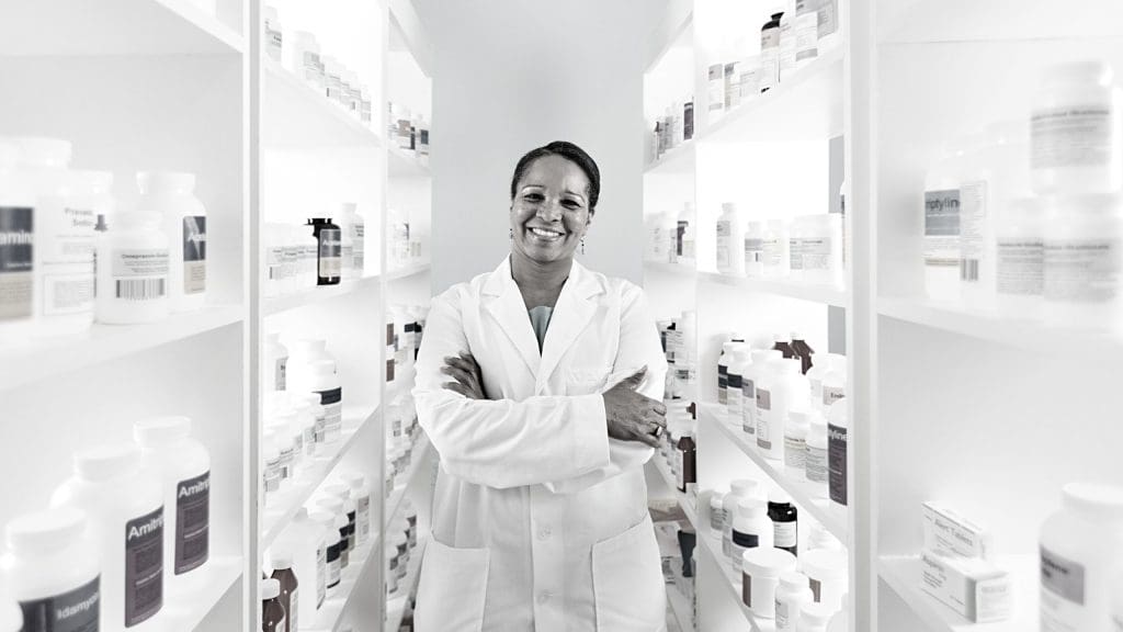 a female pharmacists standing with her arms crossed